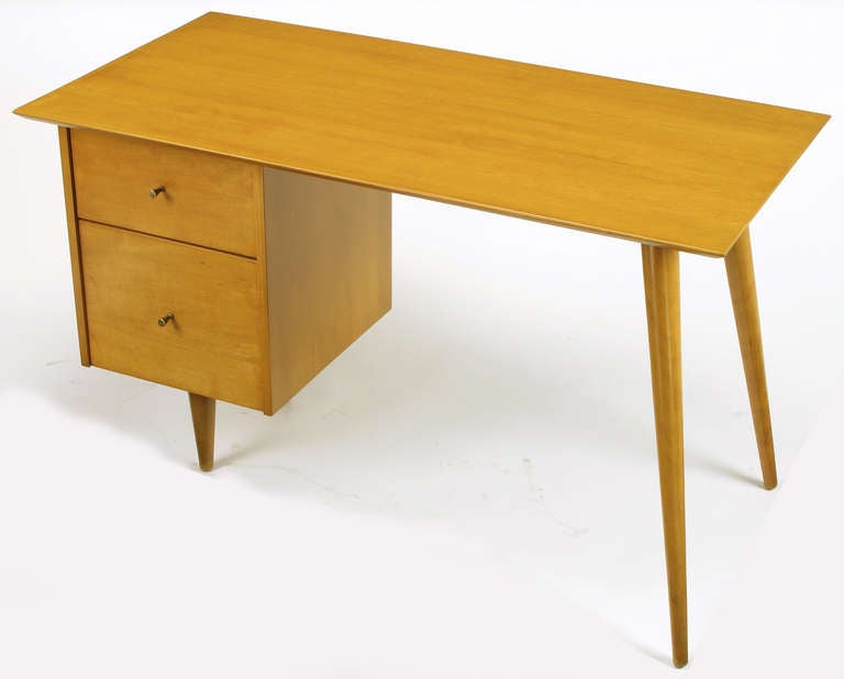 Masterfully restored to original condition, Paul McCobb Planner Group for Winchendon two drawer desk or writing table. Maple wood with brass conical pulls possessing the slightest patina.