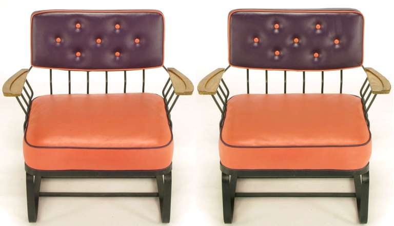 Cantilevered wrought iron, loose-cushion lounge chairs, with carved oak arms and newer button tufted plum and coral high quality vinyl upholstery. Uncommon design from top-quality metal furniture maker, Woodard.