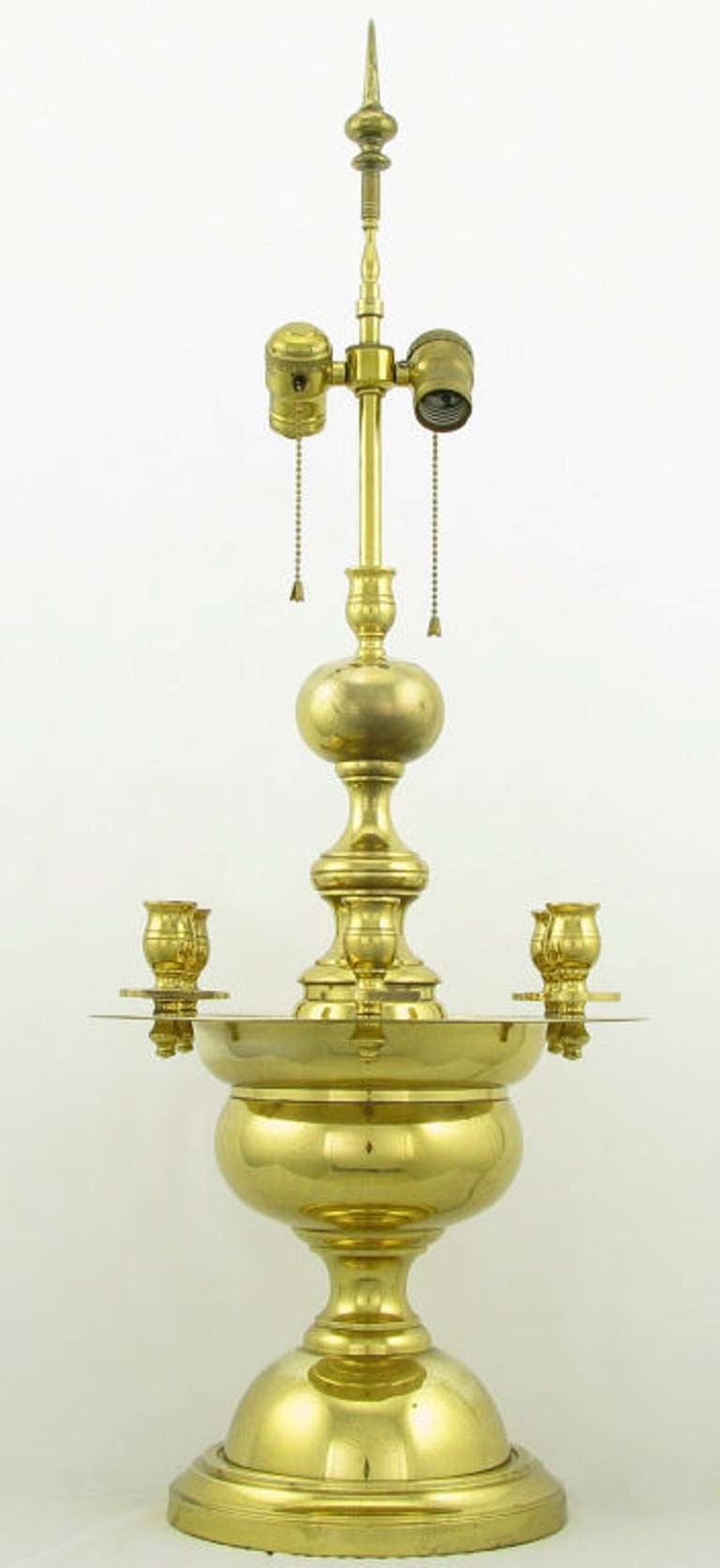 Pair of heavy bodied Regency table lamps with a candelabra of six cups in polished brass. Dual socket illumination with pull chains and ball and spear finial. Possibly from Marbro or Rembrandt Lighting, sold sans shades.