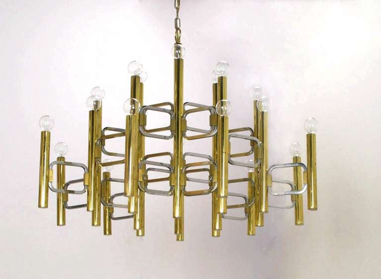 Large and geometric, this Lightolier chandelier by Italian lighting designer Gaetano Sciolari has twenty-two lighted brass tubular arms, with rectangular chromed metal geometric spacers. Sold with 21