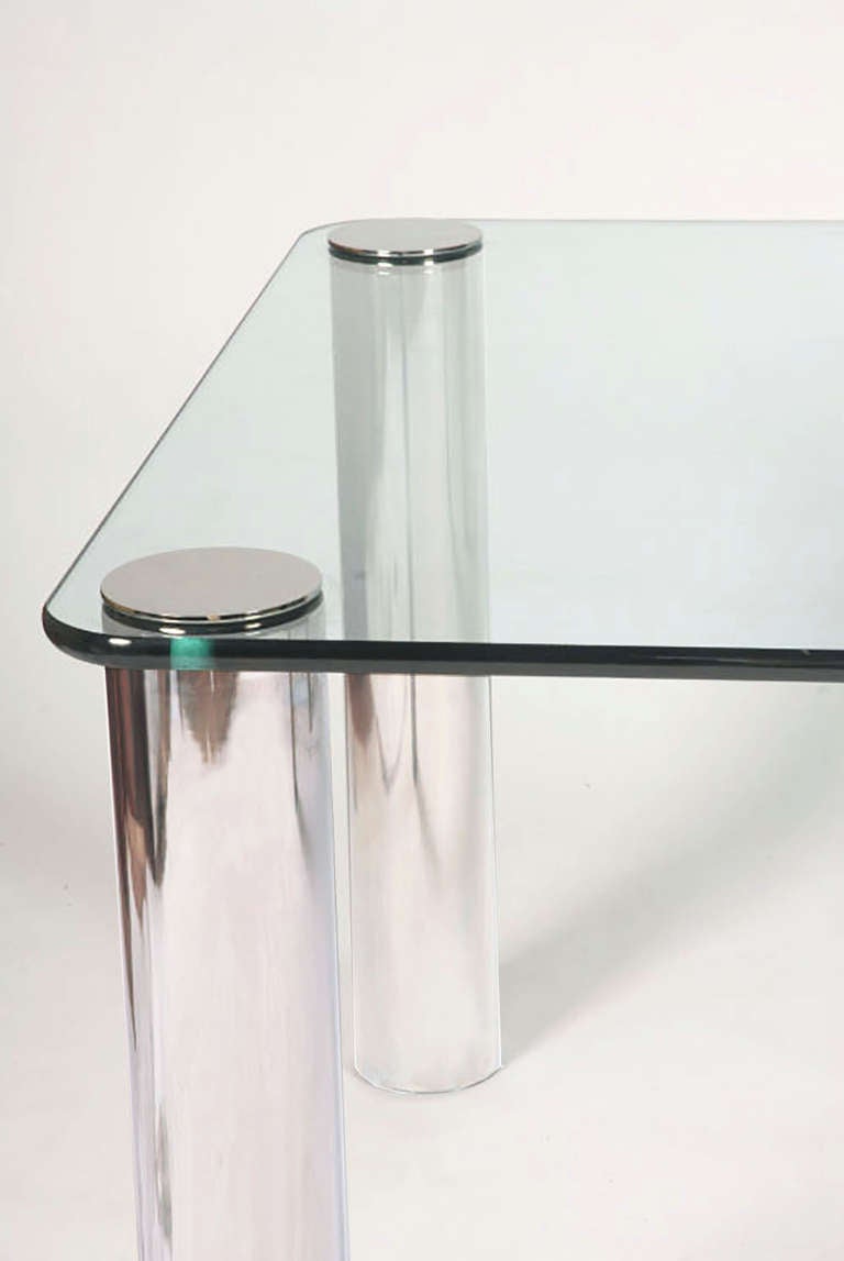 Four heavy chrome-plated legs support and pierce the top, surmounted by cast chrome caps. Radiused corner rectangular glass topis 5/8