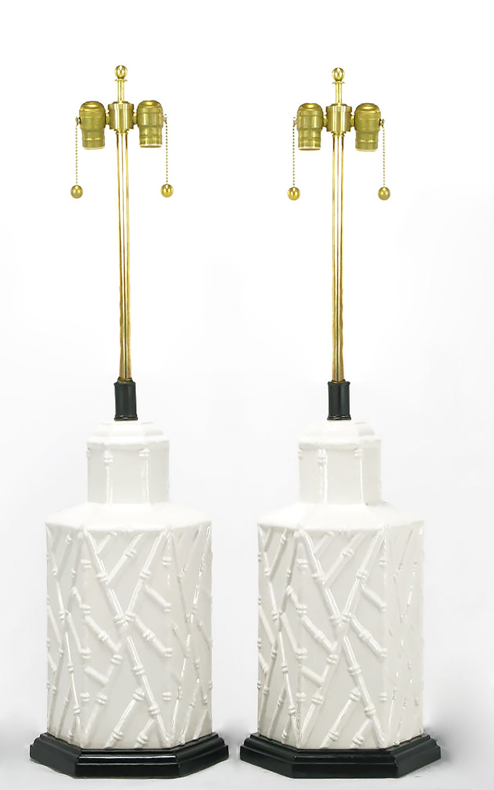 Pair of hexagonal shaped white ceramic bodied table lamps, with a patterned bamboo relief. Black lacquered and stepped hexagonal wood base and black lacquered metal and brass stems with double socket clusters. Sold sans shades.