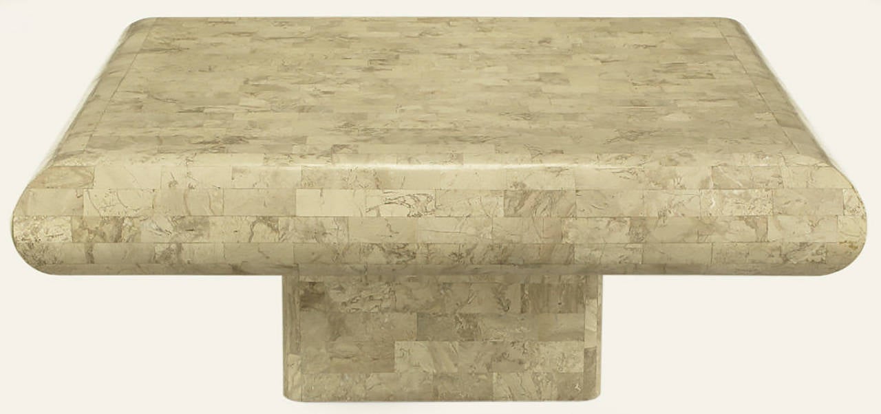 Tessellated fossil stone coffee table with radiused edges and recessed pedestal base. Made in the same factory as similar designs by Karl Springer and Maitland Smith.