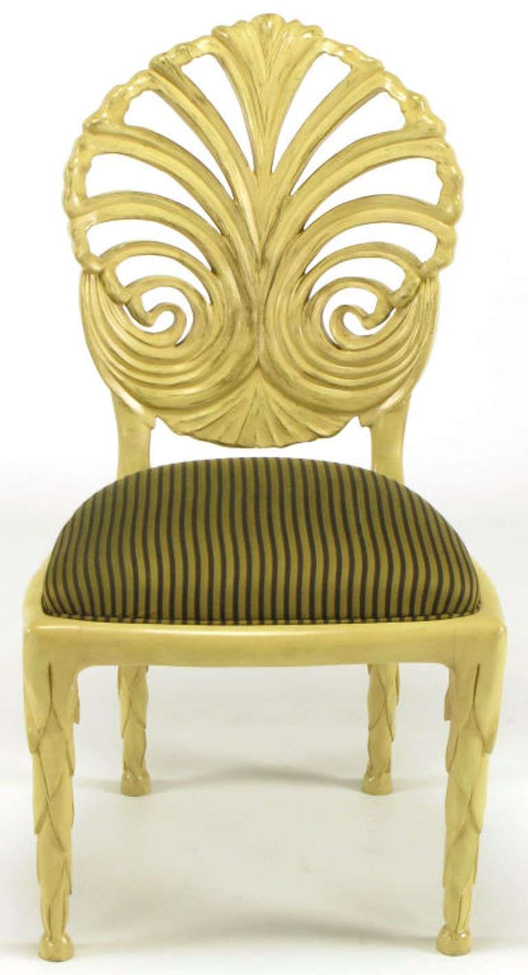 Pair of Venetian style carved wood and ivory glazed grotto chairs with pierced backs and stylized laurel leaf carved legs. Seats covered in a black and gold striped silk upholstery. By Phyllis Morris.