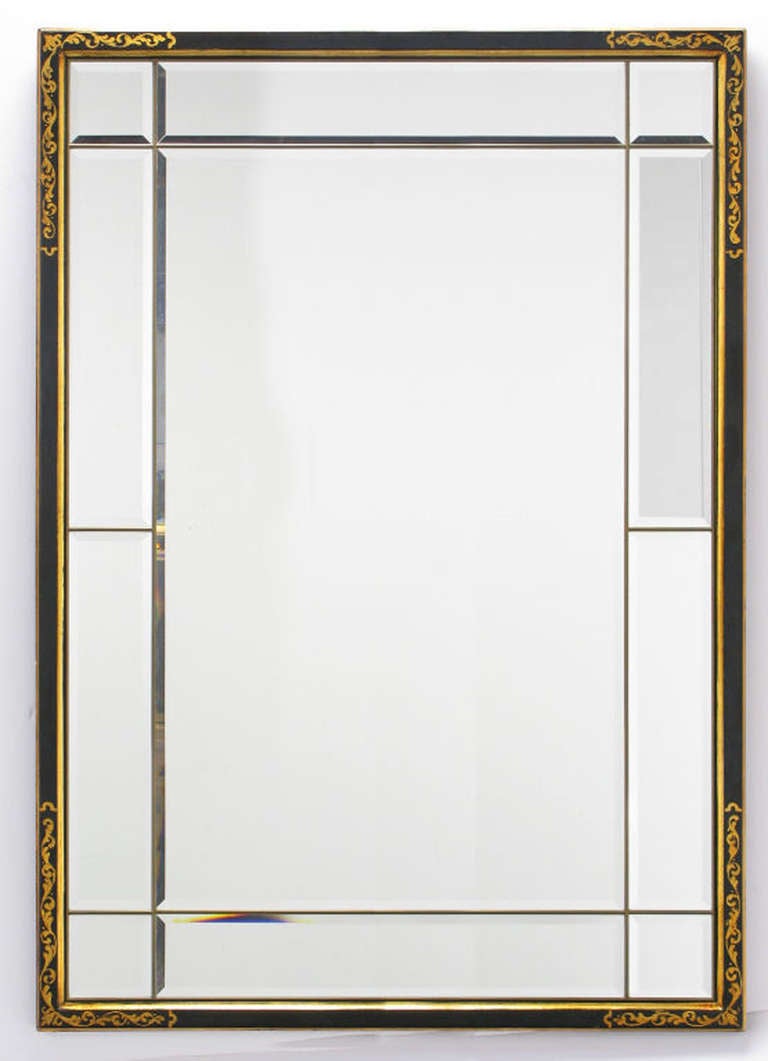 LaBarge regency style mirror with a black lacquered and parcel giltwood frame. The mirror iteself has an internally beveled mirror border in ten parts with the center mirror also having a beveled edge.