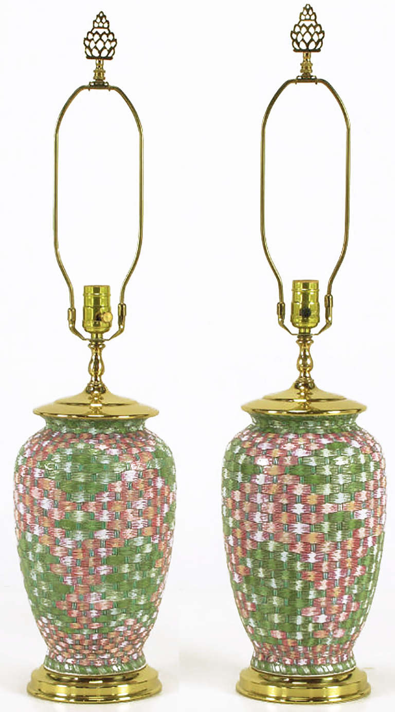 Pair of Asian inspired table lamps by L & W Lamps of Barrington, IL, a custom lighting manufacturer to the trade. Ceramic urn form bodies with a textured weave pattern with a pink and green glaze over white. Brass base and cap with brass stem,