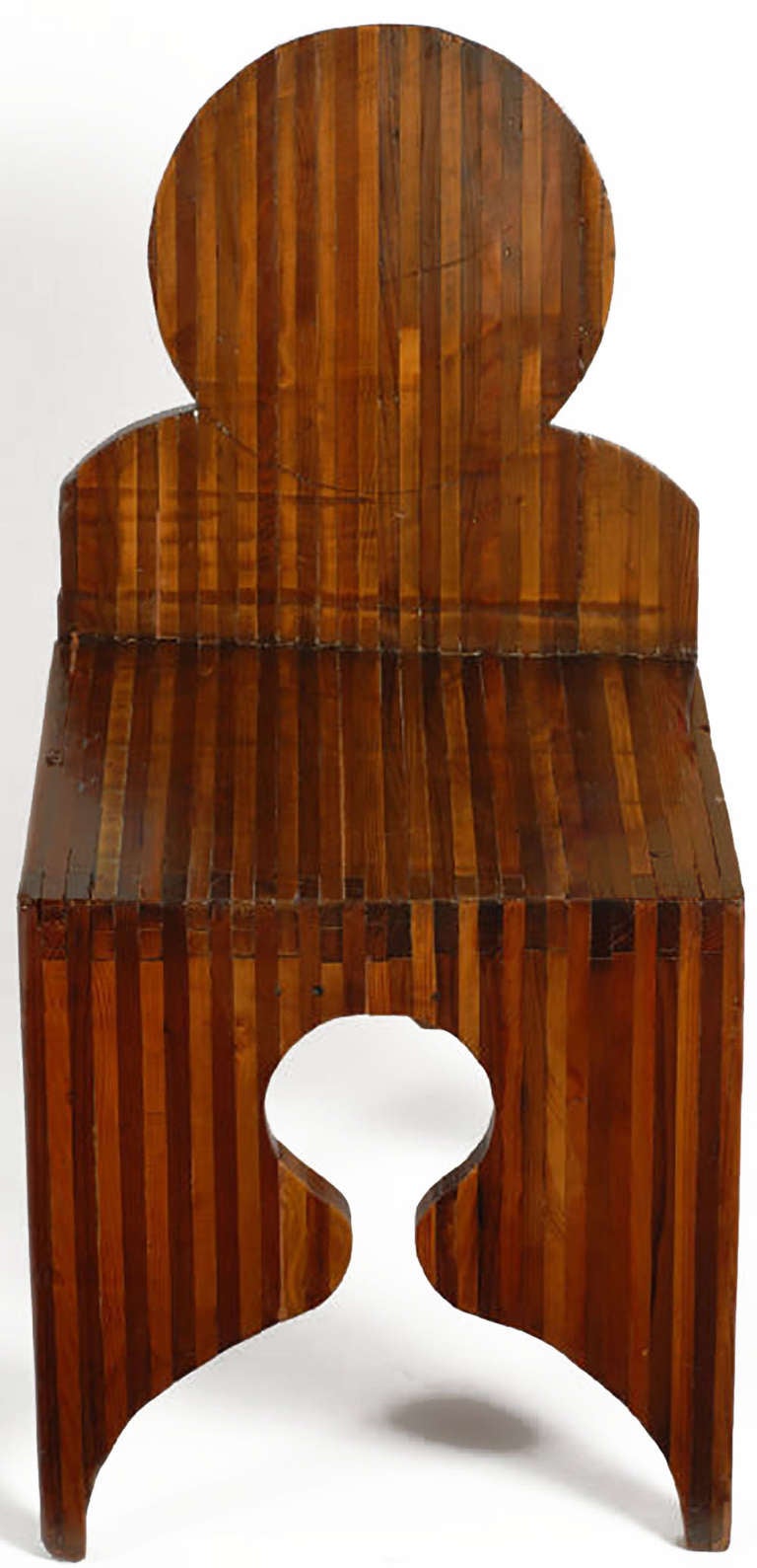 Consisting of lighter and darker woods laminated together for strength and geometry, this handmade chair sculpture had to have been a work of art brut. Round seat back echoed in the keyhole cut-out of the front and back bases.