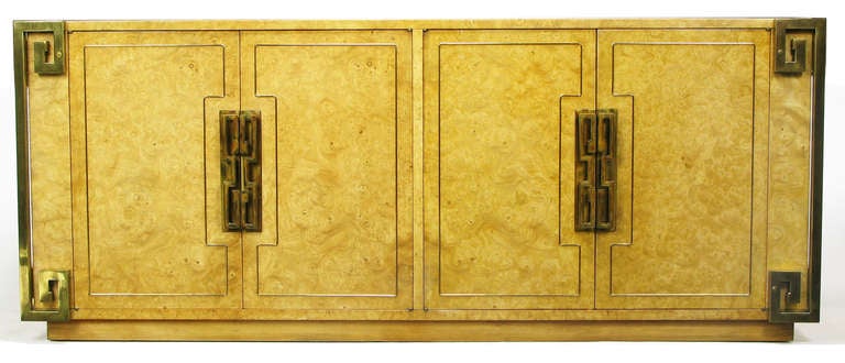 Natural amboyna burl case, with four brass-welted doors accented by heavy brass pulls and backing plates. Doors open to reveal five drawers and a single shelf. Four corners are adorned with heavy brass Greek key detail. Early cloth label.