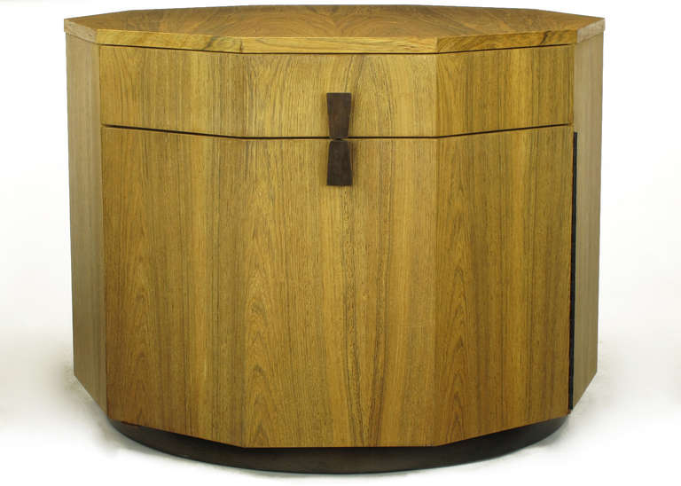 Seldom seen Harvey Probber bleached rosewood decagonal bar cabinet with single drawer and piano hinged door with integral shelving. Door and drawer are accessed via a split hour glass shaped rosewood pull. Mounted on a round dark walnut base. Open