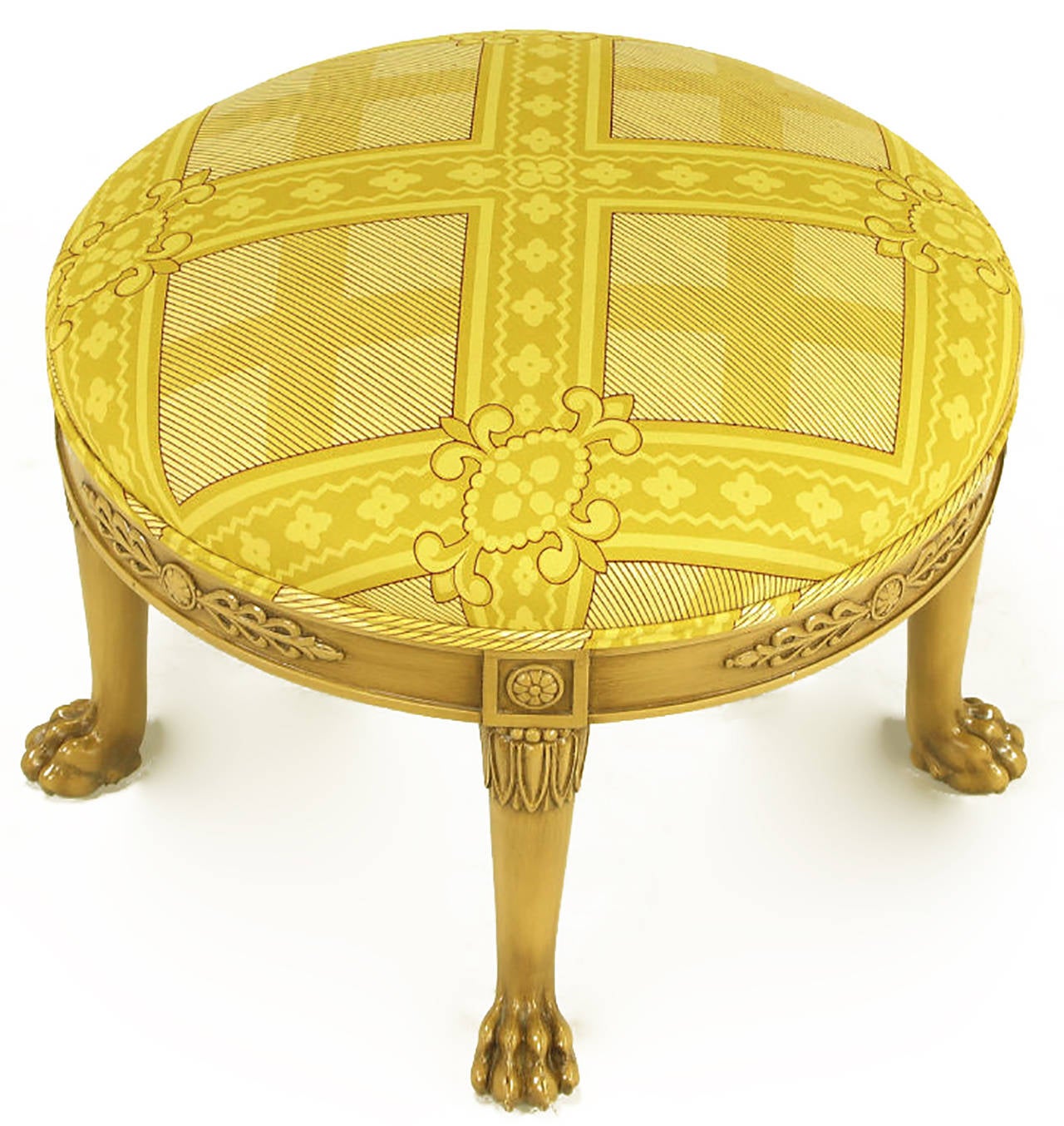 Round Empire style ottoman in bleached and glazed mahogany with lion paw feet. Legs have beaded and stylized acanthus leaf detailing. The carved and recessed apron features rosettes and horizontal plumed detail. Upholstered in a saffron print silk.