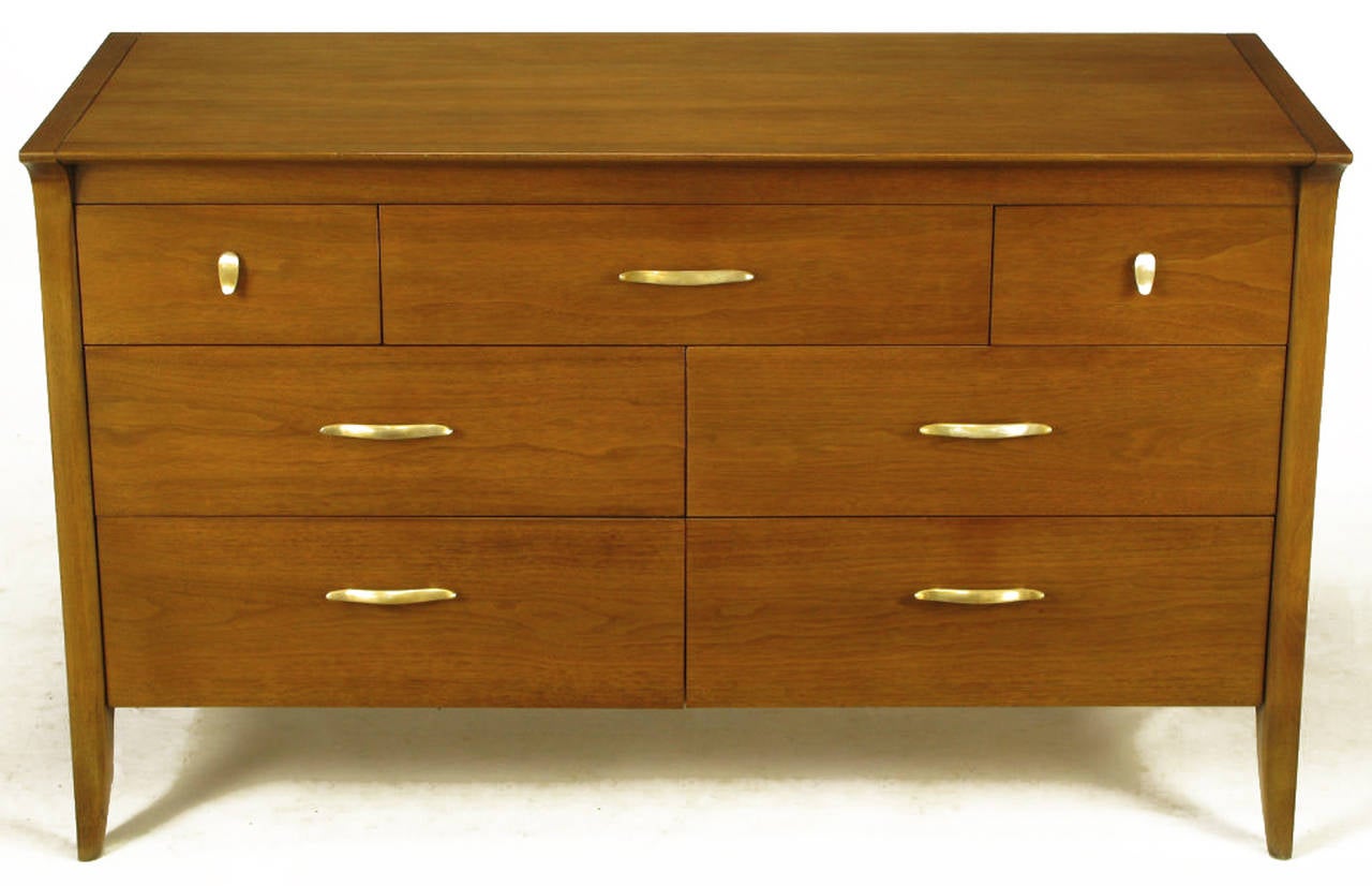 Walnut seven-drawer dresser by John Van Koert for Drexel's Profile group. Cantilevered front top edge and tapered saber legs with radius corner side openings. Brushed and toned aluminum pulls.