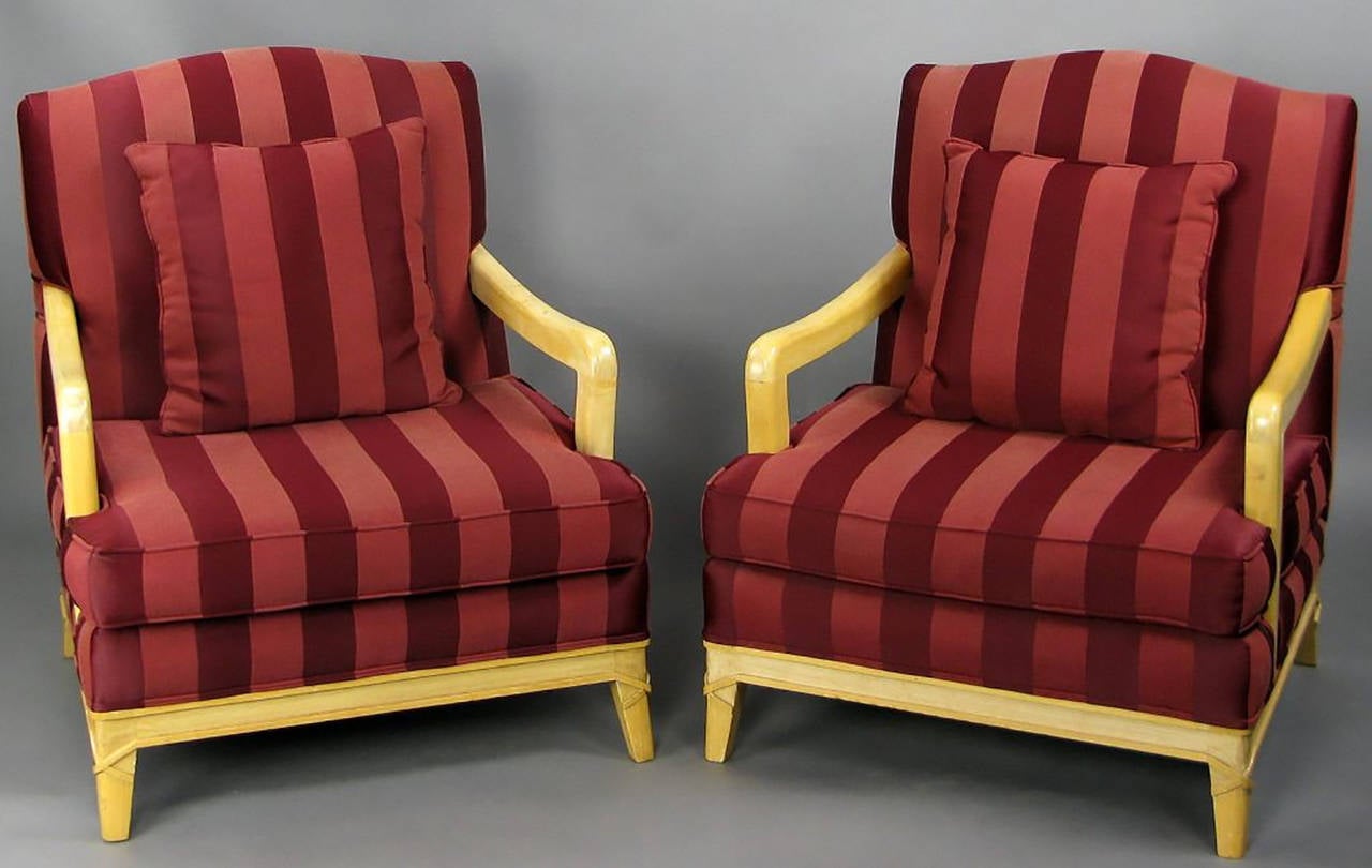 Rustic and refined pair of camel back open-arm lounge chairs. Carved wood frames with a distressed lacquer finish. All four legs have wood carved to simulate rawhide banding. Upholstered in a two-tone oxblood silk stripe fabric.