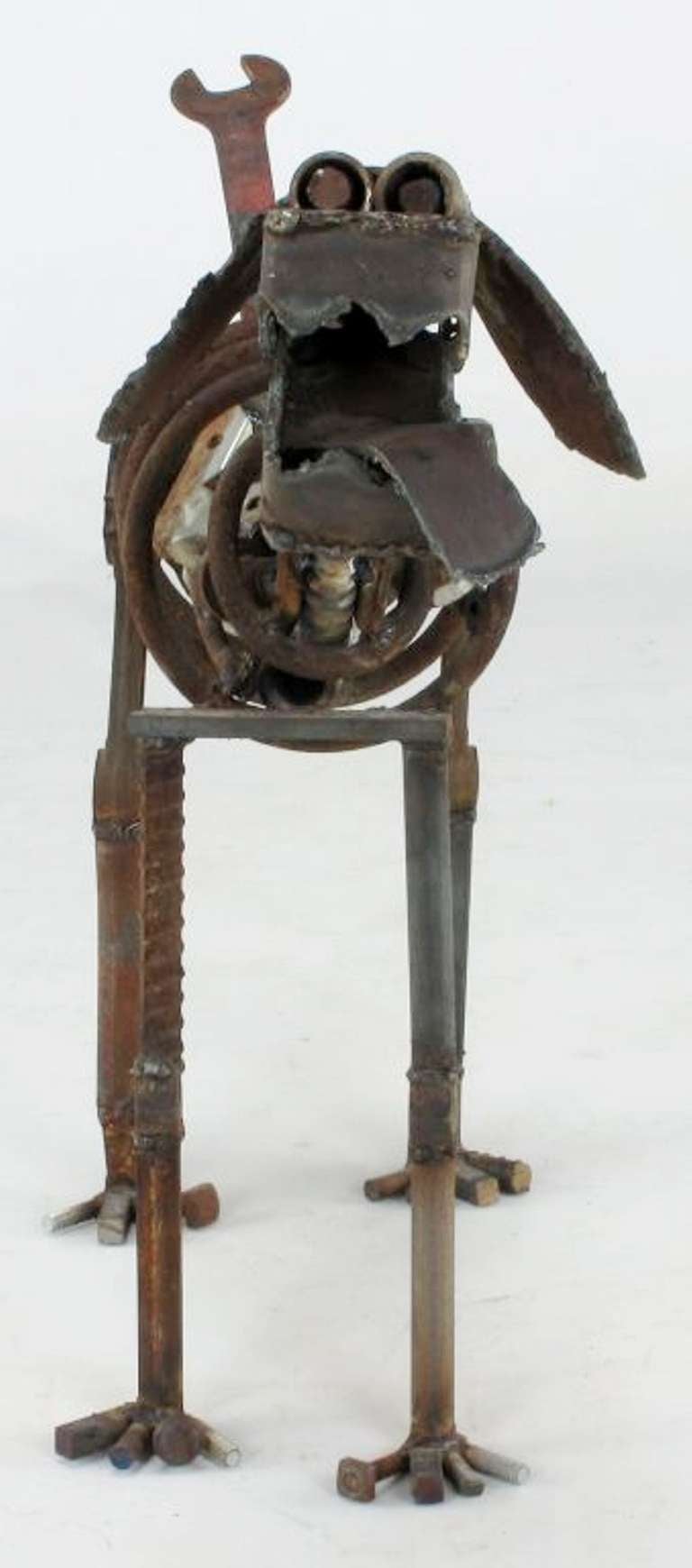 Welded iron dog sculpture composed of antique iron tools, engine parts, springs, bolts, nuts and torch cut sheet metal and reinforcing bar pieces. Signed K.P.