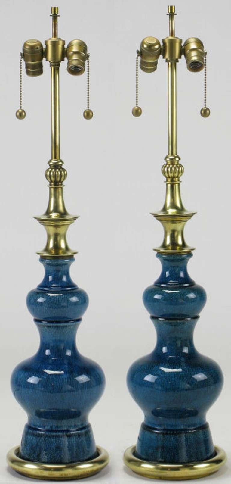 Beautifully crackle glazed blue ceramic bodied table lamps by Stiffel. Solid brass pagoda style spacers with ribbed melon form cap. Solid brass stem and double sockets with ball and chain pull switches. Sold sans shades.
