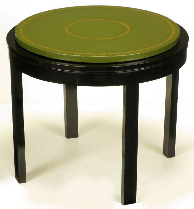 Ebonized and French polished round wood-base side table with raised wood top clad in tooled green leather. Reminiscent of some Tommi Parzinger designs for Charak Modern.