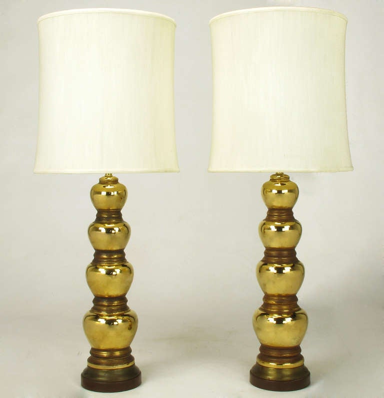 Pair of 1930s gold plated and brown glazed porcelain quadruple gourd table lamps. Mirror like finish to each gourd with a brown semi opaque matte glaze to the spacers in between each gourd. Patinated brass and chocolate lacquered two part base. stem