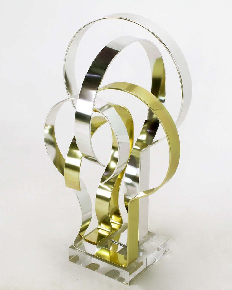 Brass effect & natural polished aluminum sculpture mounted on Lucite titled 