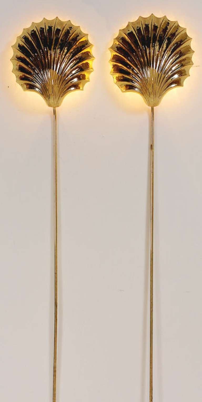 Stunning pair of brass shell sconces that mount in place. They glow atmospherically against a wall. Tubular brass cord covers provide a finished look.