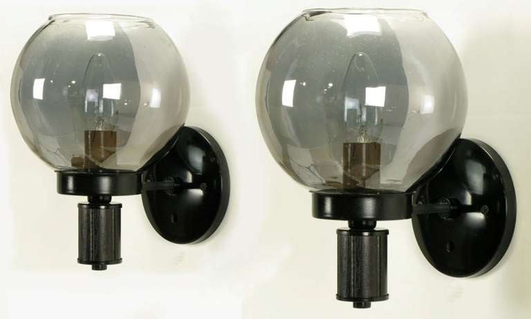 Pair of interior sconces with black lacquered metal cups and back plates. Ebonzized and incised wood stem with aged mirrored glass globes. 2 sets available, some loss/spotting to mirrored interior of the globes.