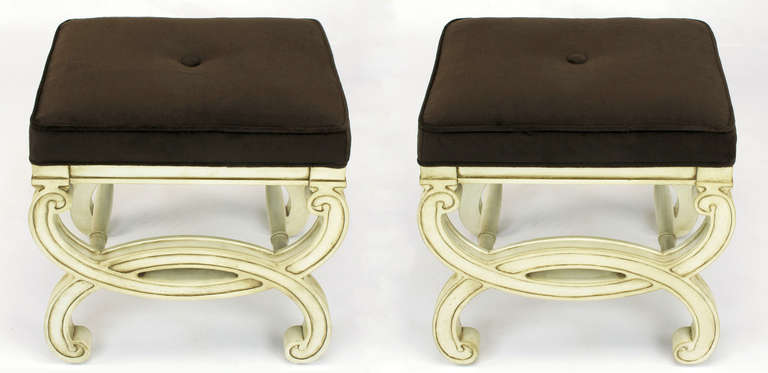 Restored pair of regency style benches with fresh ivory lacquer and umber glaze. Seats have been recovered in a sable velvet upholstery. Single button tufted. Unique in that the legs are carved to look like interlocking cuffs with turned dowel