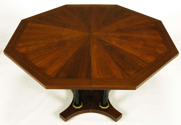 Empire revival dining or center table with an octagonal parquetry walnut top. The split, reverse quatrefoil base has four black lacquered octagonal columns with gilt detailing. With the four 18