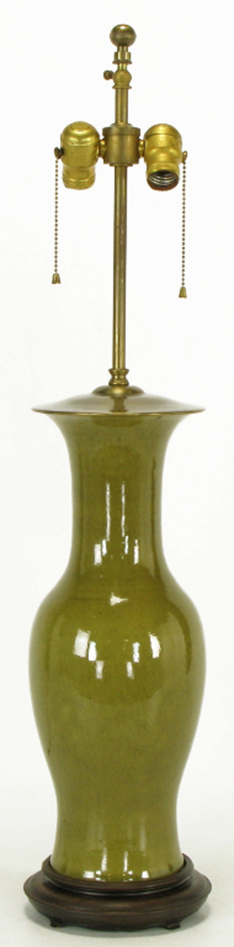 Warren Kessler ceramic vase-bodied table lamp. Excellent crackle glaze on olive green. Carved wood base with brass cap and stem, double socket cluster.