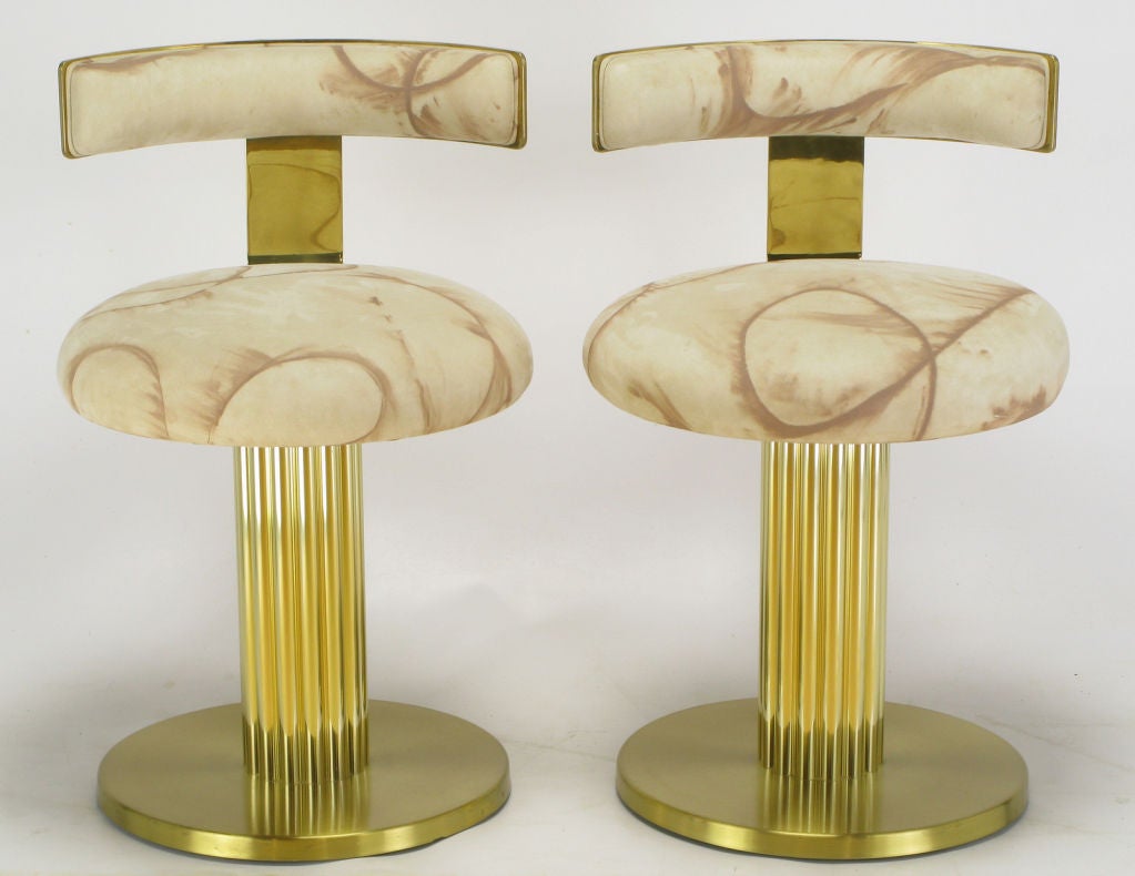 Postmodern interpretation of the traditional counter stool found in most American diners of the 1950s. Base is a reeded brass column atop a round base.  Seats and backs are upholstered in a hand painted ultra suede.