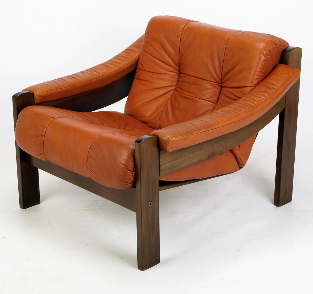 Rosewood frame and tufted pumpkin orange, or beechnut, leather sling style club chair from Norway. Soft calfskin leather is slightly distressed from normal use. Rosewood frame is dark with clear grain pattern.