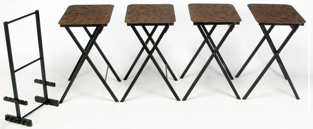 Elegant set of four black lacquered and tortoise shell finish folding tray tables, with black lacquered stand. Collapsible black lacquer X frame and single stretcher.  Portably perfect for individual servings or tea.  Made by Artex-Green Corp. of