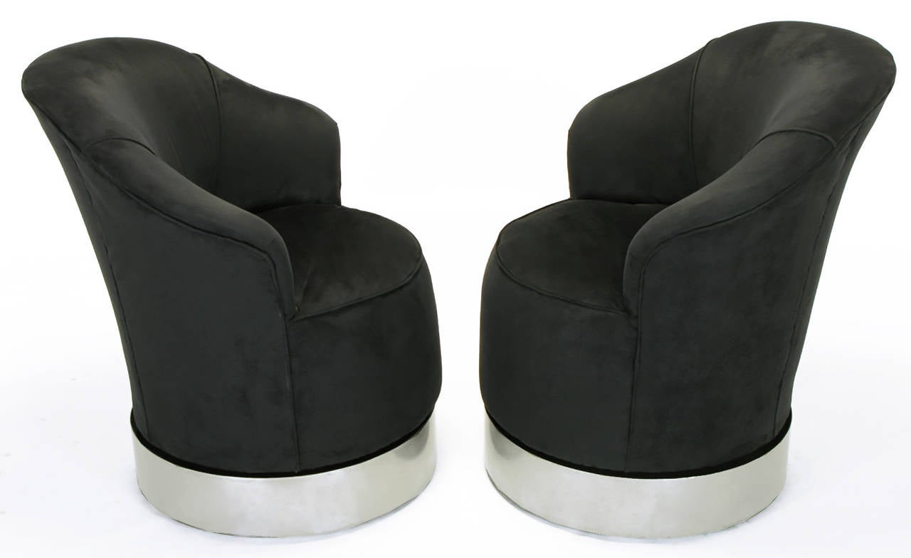 Dark blue and black ultrasuede upholstered barrel chairs, with brushed steel ring swivel bases, by Sally Sirkin Lewis for J. Robert Scott. Chairs swivel, as well as rock gently front to back