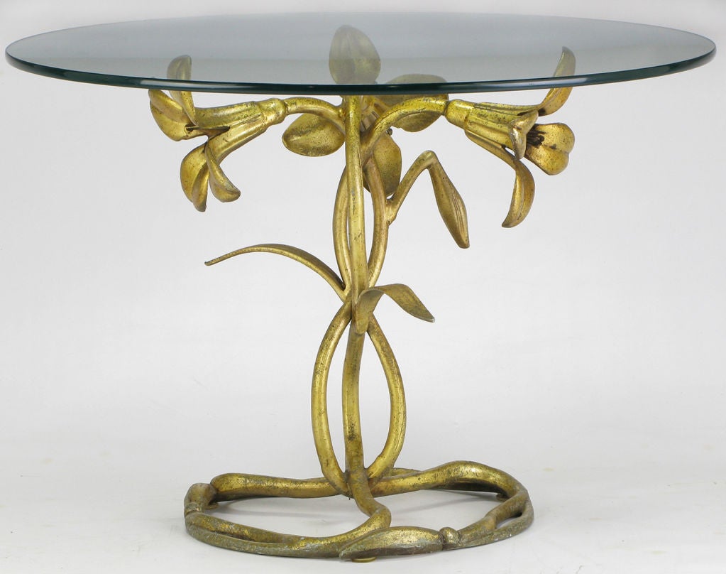 Art Nouveau and Arthur Court inspired cast aluminum side table, with an aged gilt finish. Base is comprised of three flowering lilies with intertwined stems in a figure eight pattern, finishing with a circular three sectioned base of stems and
