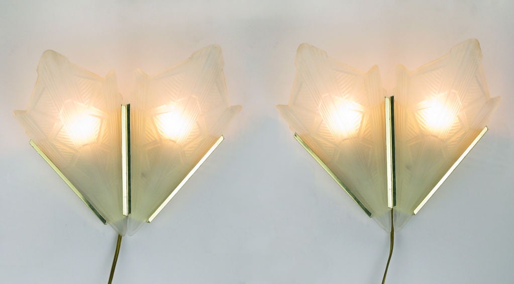 Made of antique style cast and sandblasted glass, with brass fixtures, these art deco slip shade sconces are currently wired with plugs and on/off switches. They can also be easily hard wired to a wall switch.