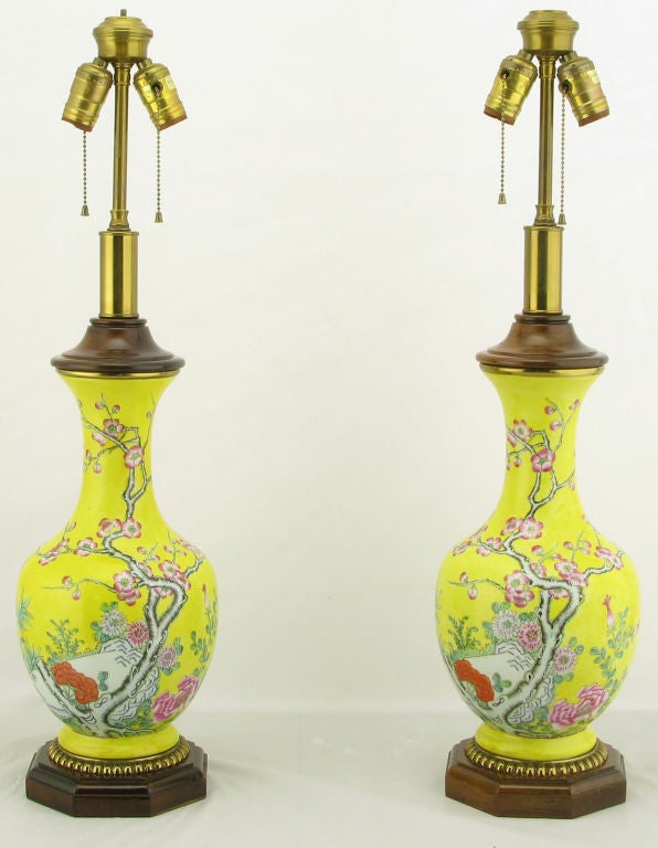 Vase form chinoiserie table lamps by Paul Hanson. The bodies are comprised of a vibrant yellow glazed ceramic vase with hand painted Eastern details. The base is carved wood, with gilt egg detail. Cap is also carved wood over a brass neck.