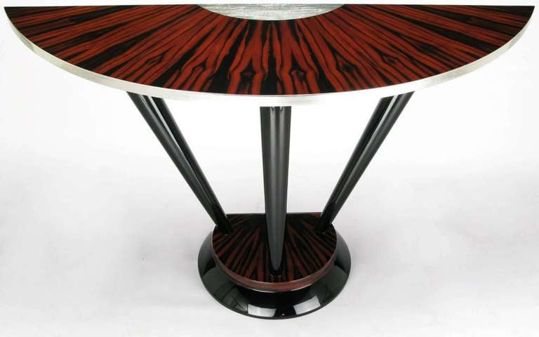 Macassar ebony and silver leaf Art Deco inspired console table.  Base comprised of black lacquered tapered wood legs and macassar ebony, all finished in a deep gloss lacquer.