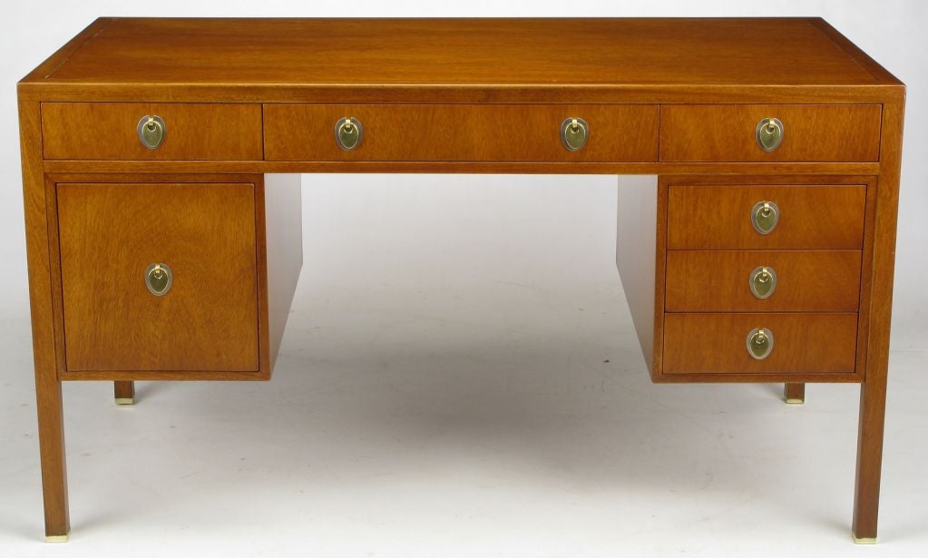 Edward Wormley for Dunbar mahogany seven drawer desk, with recessed sides and incised border top. White bronze escutcheons with ovoid yellow bronze drop pulls. Solid mahogany legs feature brass sabots.