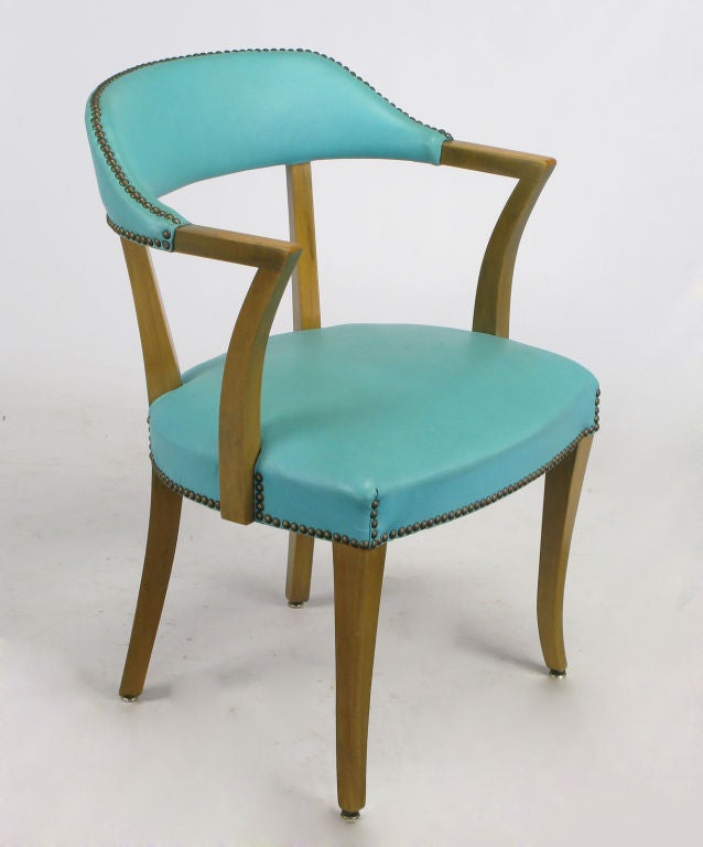 Pair of striking art deco arm chairs in bleached mahogany frames with turquoise blue vinyl covering and brass nail head upholstery tacks. We have a set of four of these chairs in our listings with black lacquered frames and sage green vinyl