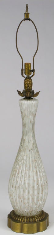 Elegant gold flecked translucent Murano glass vase bodied table lamp with cast brass base. Solid cast brass floral bobeche and pineapple spacer with brass socket and harp. Sold sans shade.