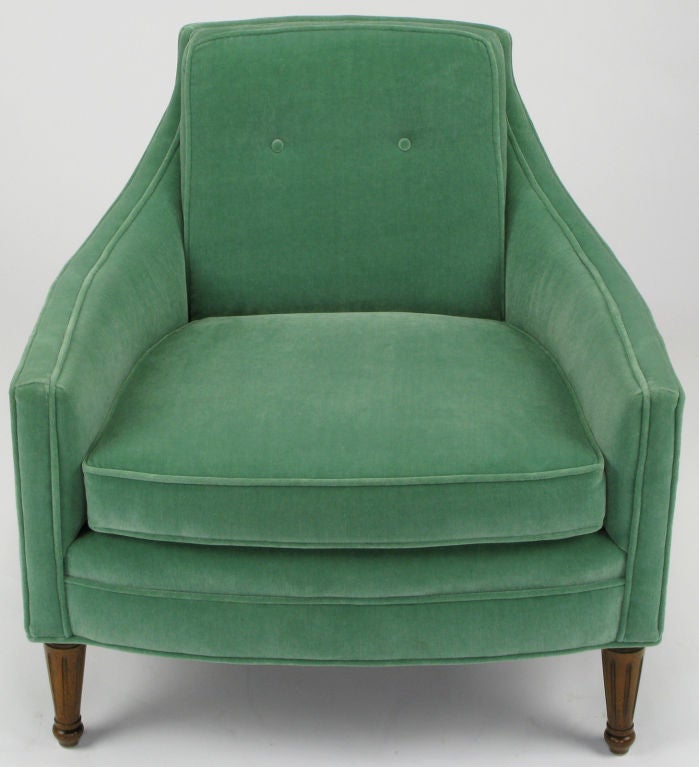 Classic modern low club chair with loose seat cushion and button tufted back in recent wintergreen velvet upholstery. Fluted wood front legs and saber style angled wood back legs.