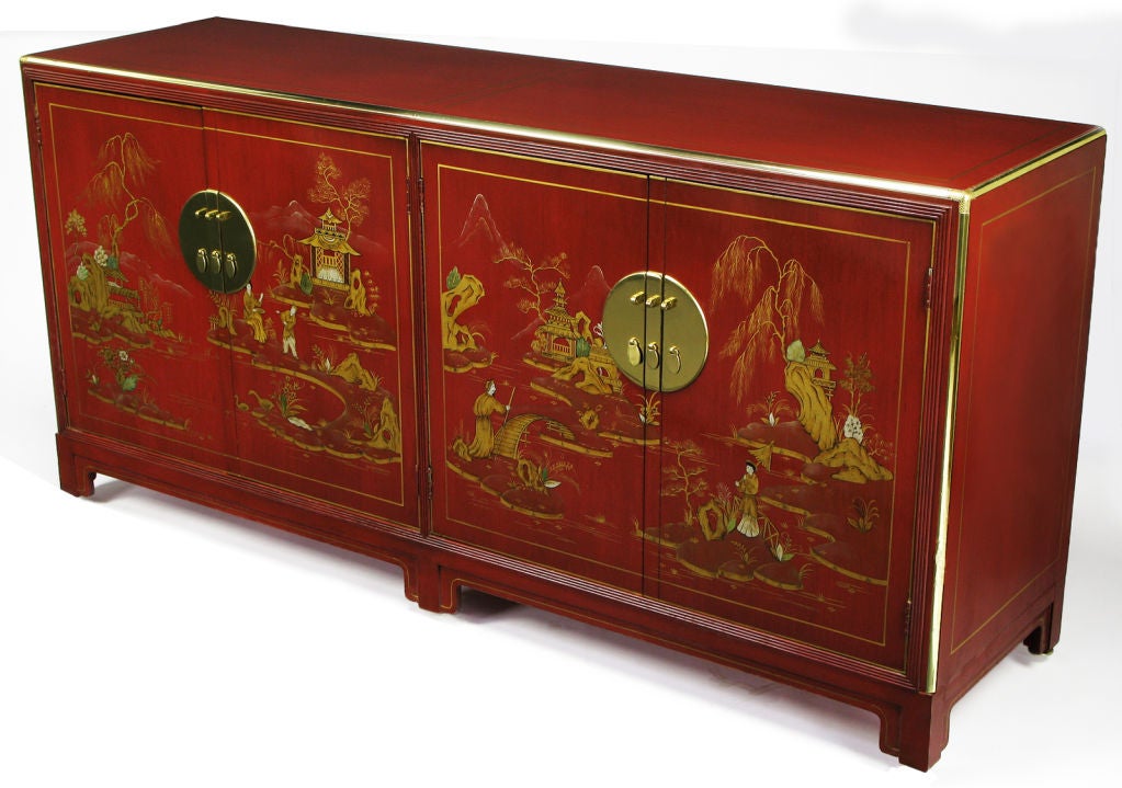 Red glazed Chinoiserie mahogany wood sideboard from Baker's Far East Collection. Clear red glaze reveals the grain pattern of the light ash wood case. Four front doors feature hand painted Asian scenes in gold, white and green.  Open via large