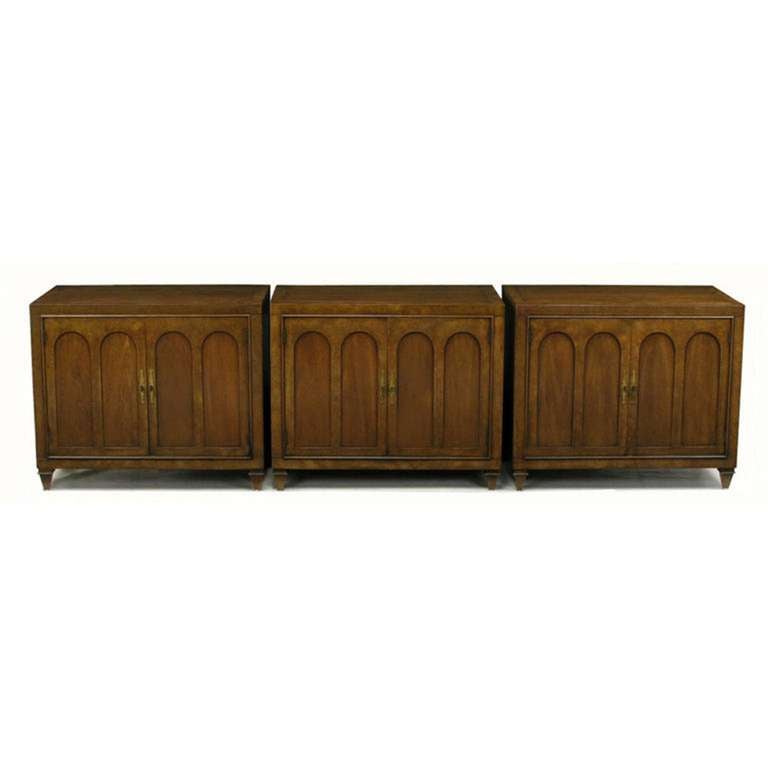 Set of three colonnade front cabinets by Mastercraft. Early pieces with the embroidered label. Burled walnut colonnade detailed doors open to reveal a large open cabinet space. Brass pulls are key style with long brass escutcheons. Tops feature