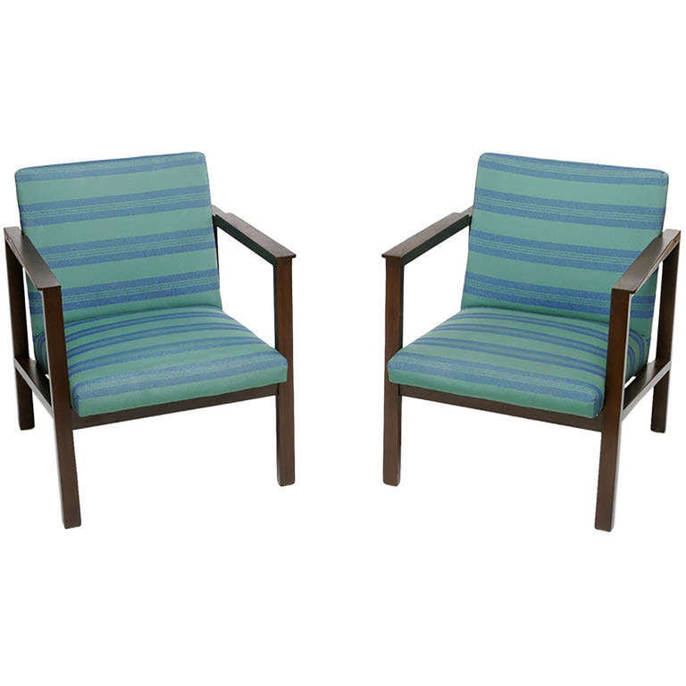 Two architectural open arm lounge chairs in walnut by Dunbar, with green and blue horizontal stripe upholstery.