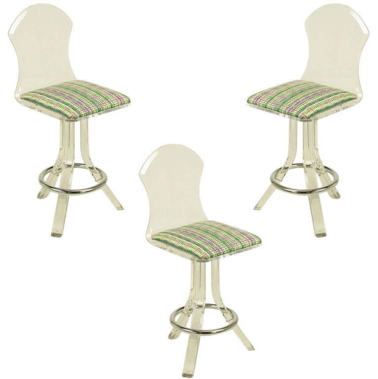 Set of three sculptural bent Lucite barstools with cotton upholstered seats in vivid emerald green, lavender and white. Bent legs attach to the seat and finished in chrome ring foot rests. In the manner of Pace Collection.