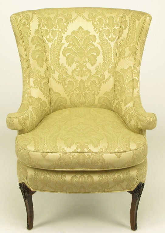With stylistic cues comparable to Grosfeld House, this classic Regency wingback chair has an updated flair. Sloping arms are raised and turn at the ends. Dark mahogany legs have a slight splayed curvature with understated carving.
