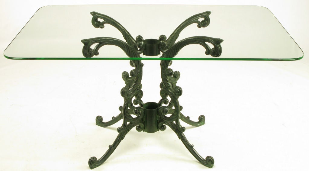 Cast aluminum scrolled arm and legged bistro table with a radius corner rectangular top. Scrolled base has been lacquered to resemble aged bronze with a dark green base tone and verdigris high lights. Can be used indoors or out.