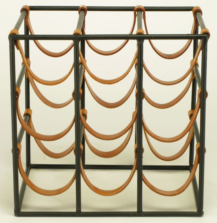 Iconic nine bottle wine rack designed by Arthur Umanoff for Shaver Howard. Wrought iron frame with riveted leather straps.
