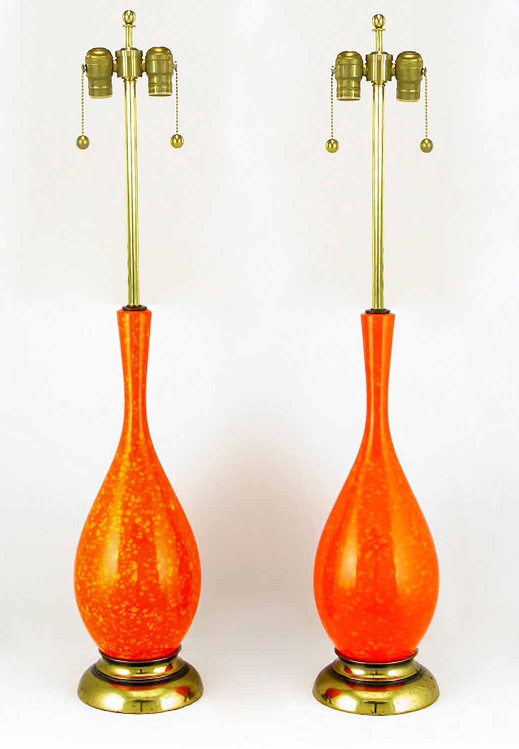Lampes de table en forme de vase à corps en céramique avec une glaçure orange kaki unique et des pointillés jaunes gamboge sur la glaçure, et des bases en laiton patiné. Les abat-jours peints à la main en finition mouchetée sont inclus. Les teintes