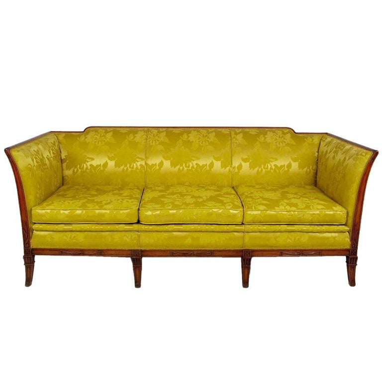 Elegantly designed sofa from the early 1940s in a beautiful gold silky damask upholstery. The frame is a wonderfully carved walnut with curved even arms and a stepped back. The legs are finished with moderate saber styling.