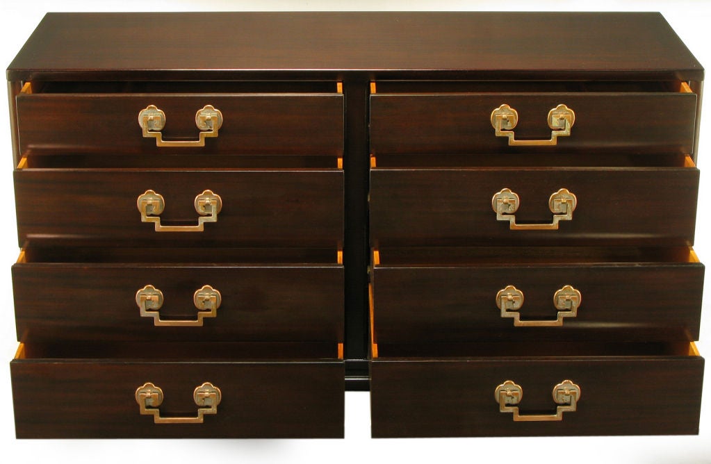 Restored to its beautiful original condition, this eight drawer dresser was manufactured by Landstrom Furniture of Rockford, Illinois. Ribbon mahogany finish, chinoiserie styling with aged copper and nickel drop greek key pulls and trefoil