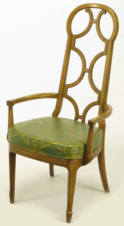 Set of eight early Mastercraft walnut dining chairs with reverse quatrefoil carved open backs, and olive green vinyl with gold filigree print fixed seat cushions. The seat includes two arm chairs and six side chairs. Great build quality and unique