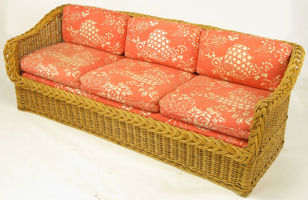 Italian woven rattan sofa by The Wicker Works of San Francisco, CA. Full size sofa at seven feet long with original coral and white print linen upholstery. Loose seat and back cushions, with removable decking.<br />
<br />
The Wicker Works was